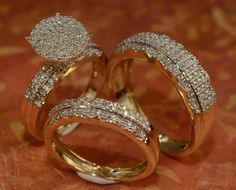 two gold rings with diamonds on them sitting on a table top next to each other