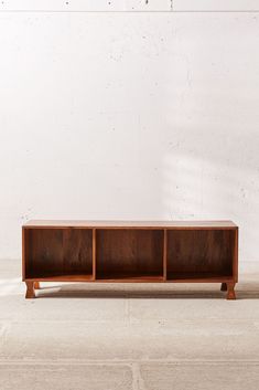 a wooden shelf sitting on top of a cement floor