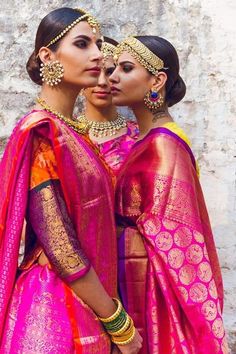 two women dressed in bright pink and yellow outfits, one is kissing the other's forehead