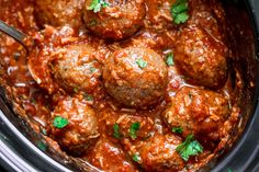 meatballs and sauce in a slow cooker with a spoon sticking out of it