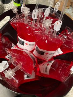 several red bottles filled with medical supplies on top of a black tray in a kitchen