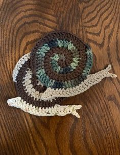 two crocheted hats sitting on top of a wooden table