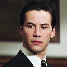 a man in a suit and tie looking at the camera with an intense look on his face