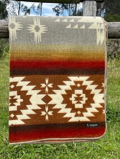 a blanket hanging on a wooden fence in the grass