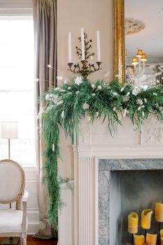 a fireplace decorated with greenery and candles