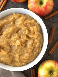 a bowl of oatmeal next to apples and cinnamon sticks