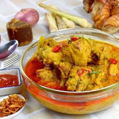 a bowl filled with food next to other foods on a table and utensils