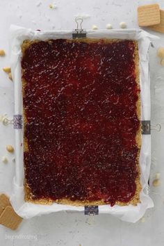 a square piece of food sitting on top of a white table next to crackers