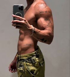 a shirtless man taking a selfie with his cell phone