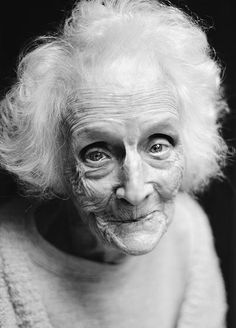 an old woman with white hair and blue eyes is looking at the camera, in spanish