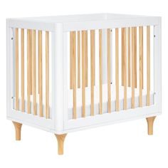 a white crib with wooden slats on the top and bottom legs, in front of a white background