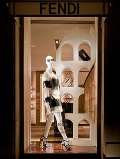 a mannequin dressed in black and white is standing outside the fendi store