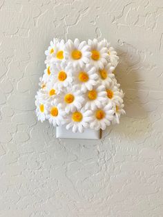 white and yellow flowers are placed on the wall