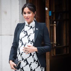 the pregnant woman is wearing a black and white dress with an animal print scarf around her neck