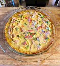 a pizza sitting on top of a wooden table next to a glass plate with toppings