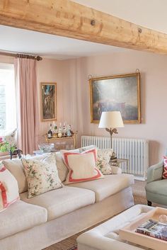 a living room filled with furniture and pink walls