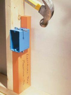 a hammer is stuck into the side of a wall with an orange and blue block