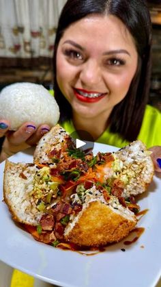 a woman holding up a plate with food on it