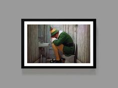 a man sitting on top of a toilet wearing a green jacket and clown hat with his legs crossed