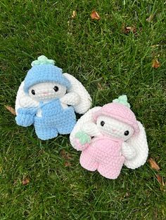 two crocheted stuffed animals laying on top of green grass next to each other