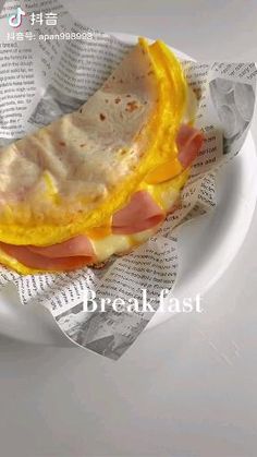 a white plate topped with a sandwich on top of paper