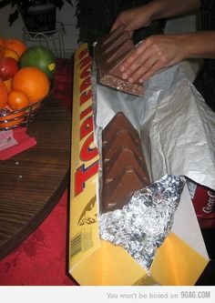 there is a box of chocolate and oranges on the table with it's wrapper