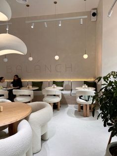 the interior of a restaurant with white tables and chairs