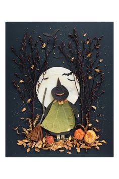 a paper plate with leaves, acorns and a scarecrow in front of a full moon