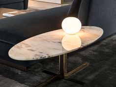 a table that has a light on it next to a couch in a living room