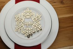 a white plate topped with a gold snowflake on top of a wooden table