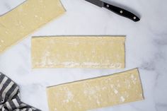 two pieces of dough next to a knife on a table