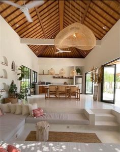 a living room filled with lots of furniture and a wooden ceiling mounted to the side of a wall