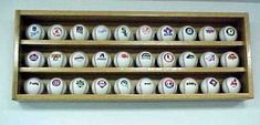 several baseballs are on display in a wooden box with numbers and symbols painted on them