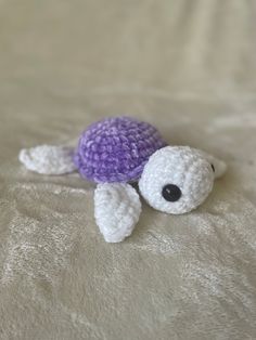 a crocheted turtle laying on top of a bed