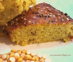 two pieces of cornbread on a plate next to some chickpeas and other food