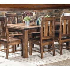 a wooden table and chairs in front of a stone wall