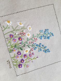 a close up of a piece of cloth with flowers embroidered on the front and back