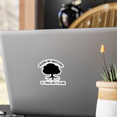 an open laptop computer sitting on top of a desk next to a potted plant