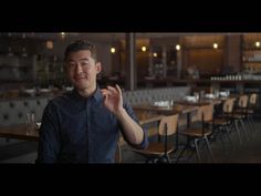 a man standing in front of tables with chairs