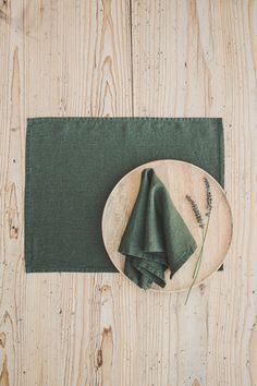 green napkins are sitting on a wooden plate