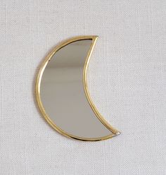 a mirror that is sitting on top of a white table cloth with a gold edge