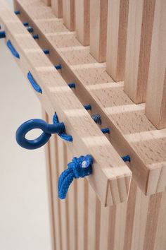 a blue pair of scissors hanging on a wooden board with rope attached to the handle