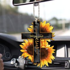 a cross with sunflowers is hanging from a car dash board in front of the dashboard