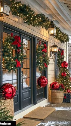 christmas decorations on the front door of a house with lights and wreaths hanging from the windows