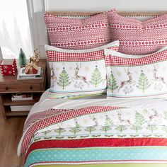 a bed covered in red and green christmas themed sheets