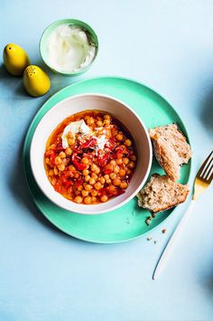 a bowl of beans and bread on a plate