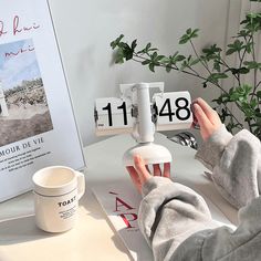 a person sitting at a desk with their feet up on a table next to a coffee cup