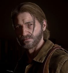 a man with long hair and beard standing in a dark room looking at the camera