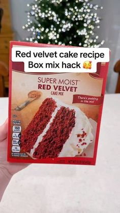 a red velvet cake in a box with a christmas tree in the background