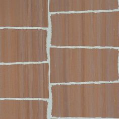 a brown brick wall with white lines painted on the side and one line drawn across it